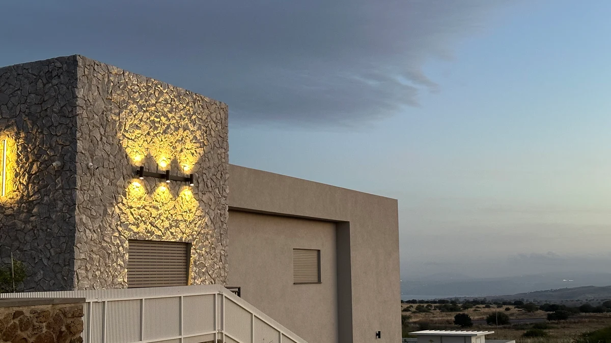 Illuminated stone exterior of Zimmer BaRama against the evening sky